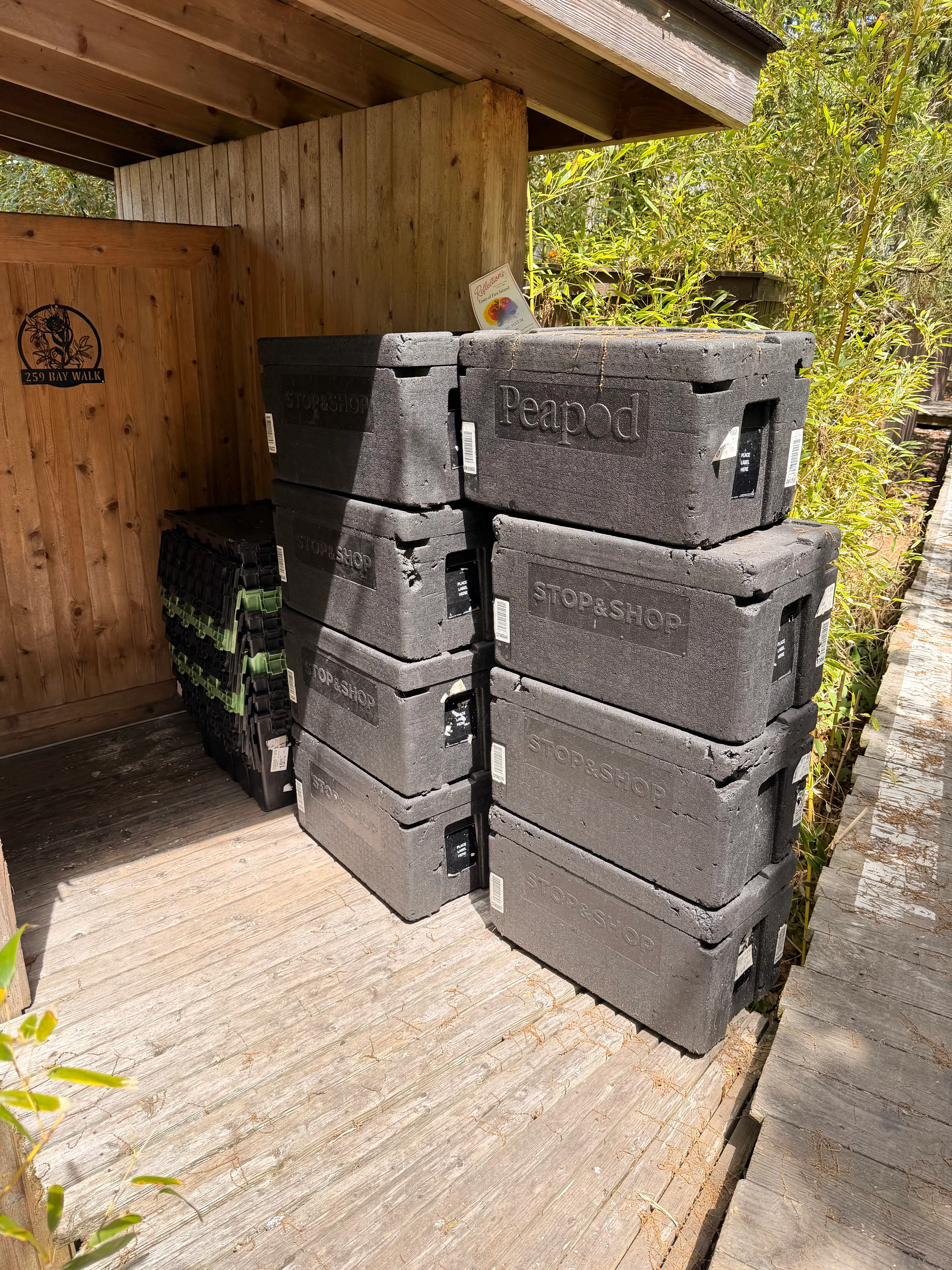 Stacked Stop & Shop and Peapod grocery freight totes on a Fire Island Pines deck.
