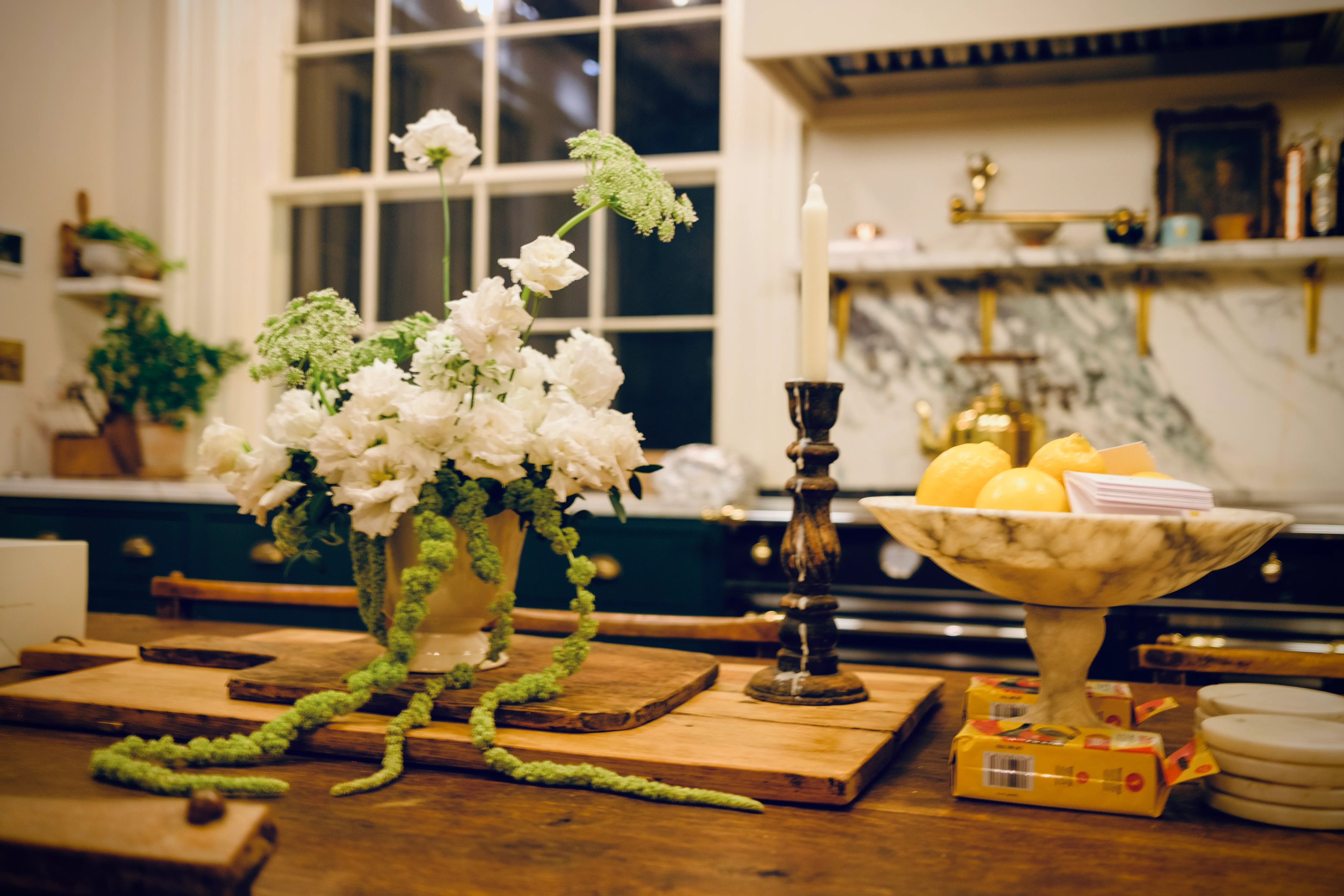 A kitchen countertop styled with fresh flowers and citrus — a welcome in progress.