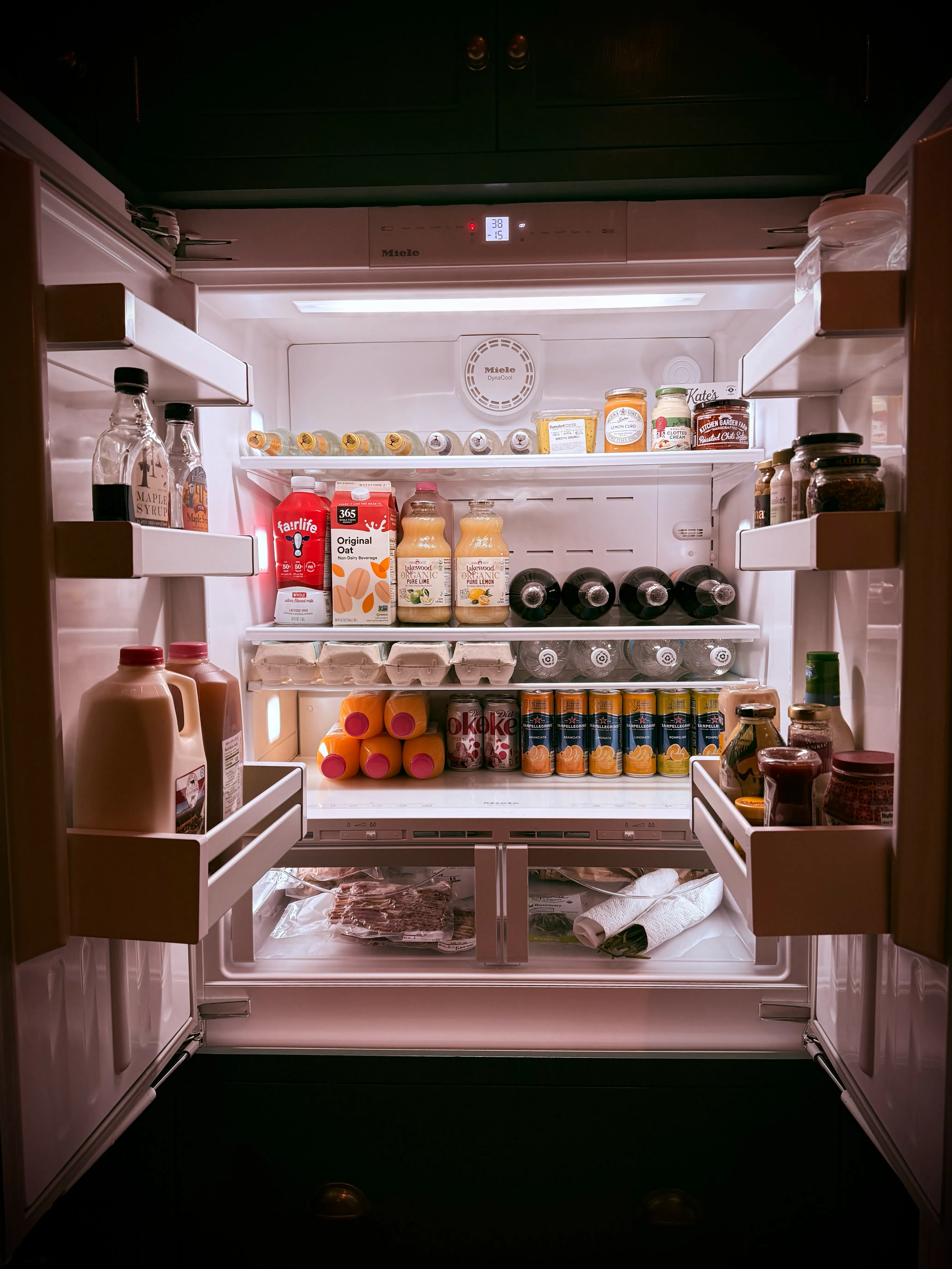 A refrigerator freshly stocked with groceries, drinks, and fresh produce, ready for the owner’s arrival.